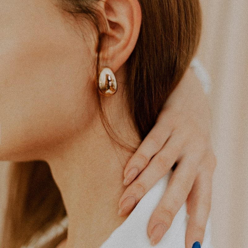 woman wearing silver diamond stud earring