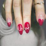 selective focus photography of woman's pink manicure