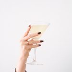 person holding clear martini glass