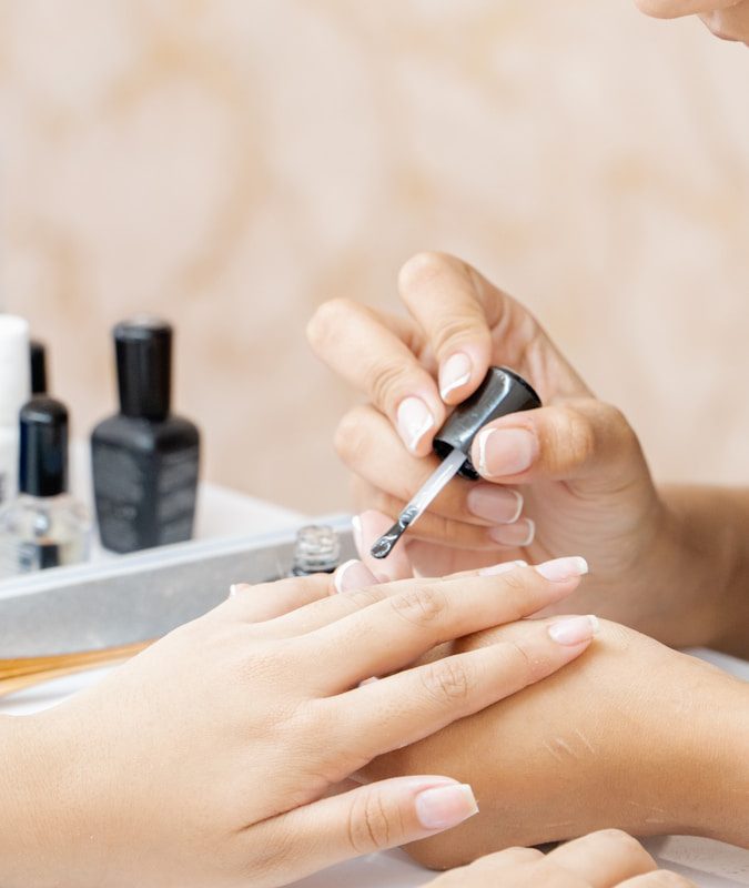 a woman is doing a manicure on a child's hand
